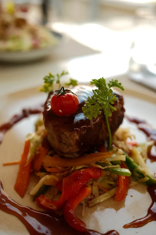Campaña de redes sociales de un restaurante mostrada en un celular sobre una mesa con platillos