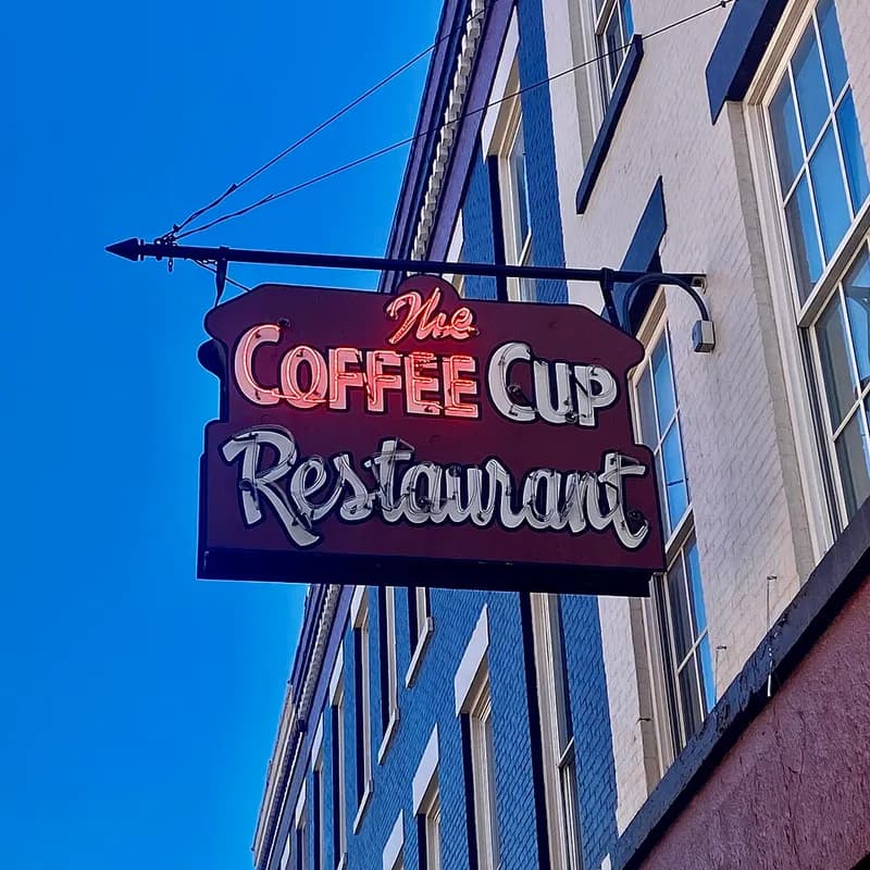 Taza de café sobre la mesa de un restaurante con ambiente de negocios