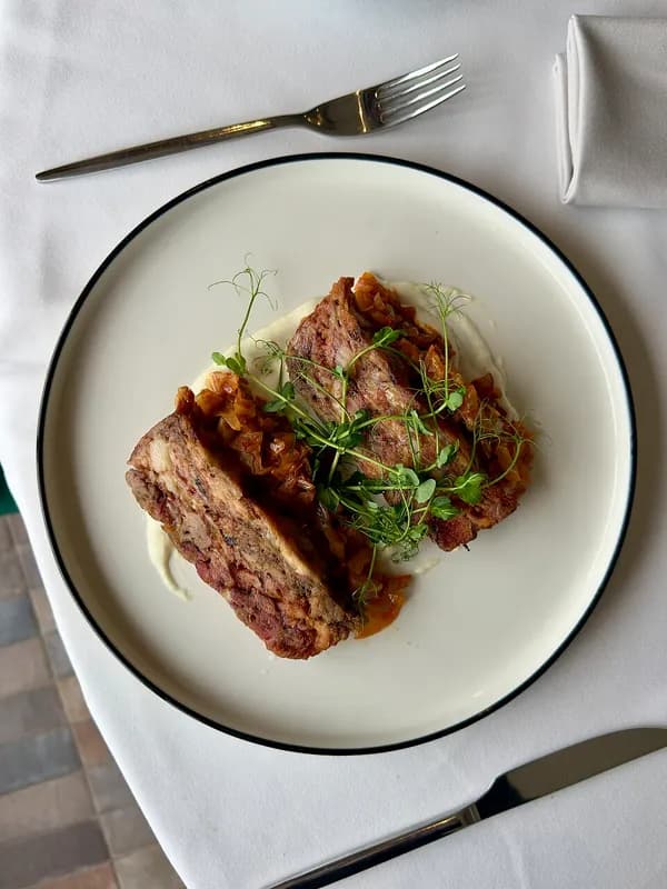 Platillo recién servido en un plato blanco sobre mesa de restaurante