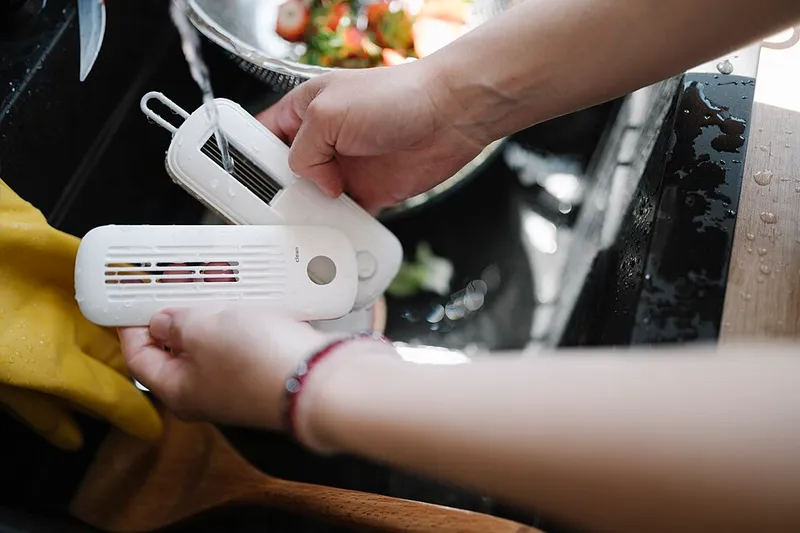 Manos con guantes desinfectando y limpiando superficies de cocina