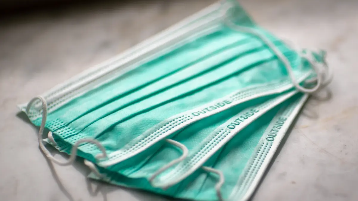Manos con guantes desinfectando y limpiando superficies de cocina
